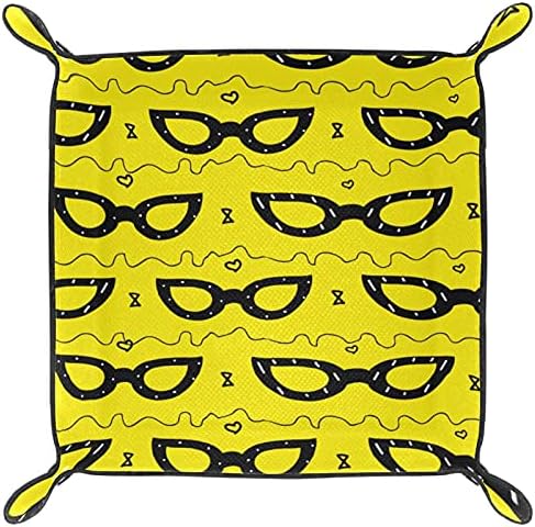 Žuta mačja naočala za naočale za daljinski upravljač pored pladnjesti ispraznosti